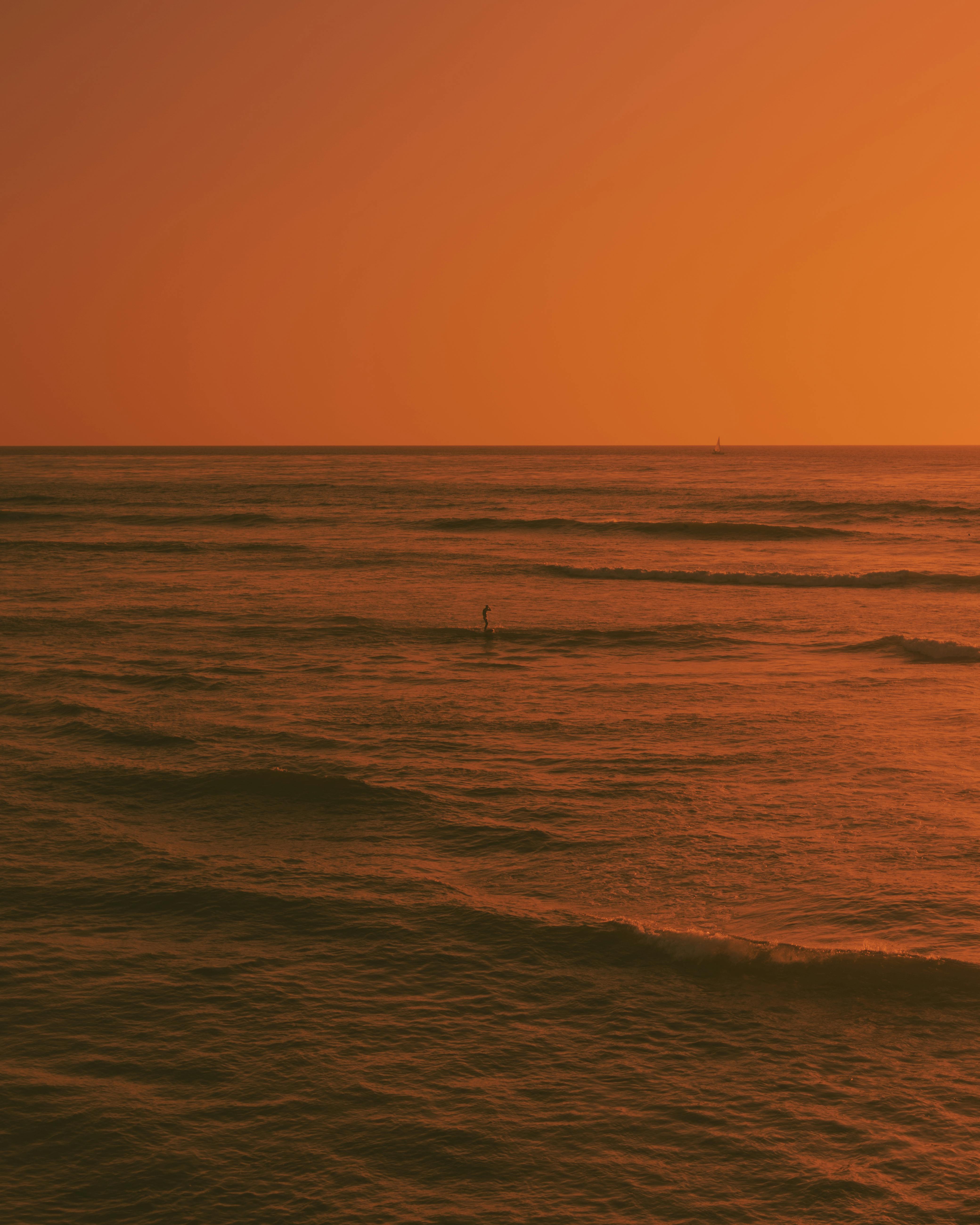 Capture the serene beauty of a golden sunset over the San Diego sea with gentle waves and a warm horizon.