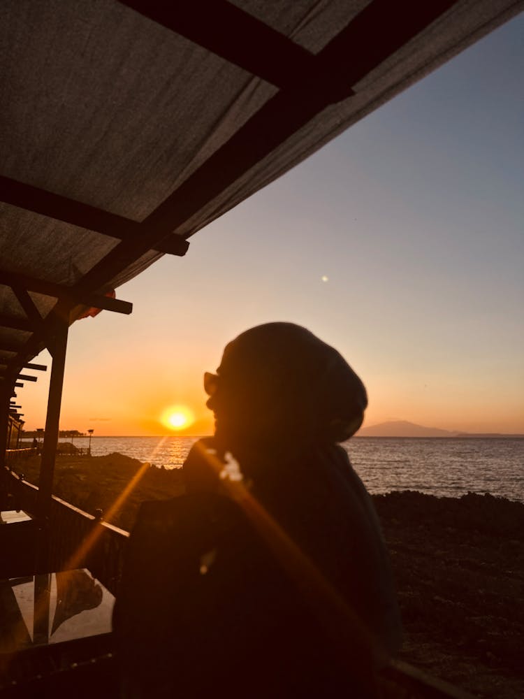 Woman In A Cafe On The Beach At Sunset 