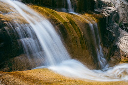 Captivating waterfall cascading over mossy rocks, creating a tranquil nature scene.