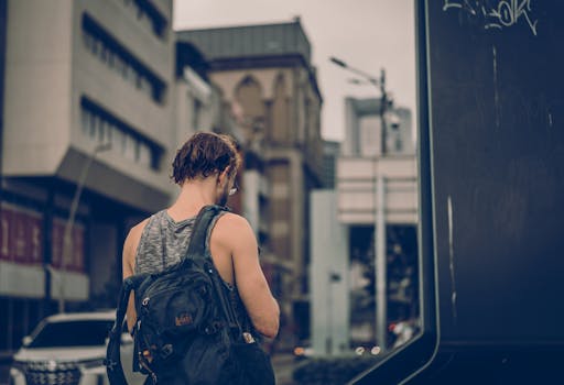 Back view of a man with a backpack exploring urban Kuala Lumpur.