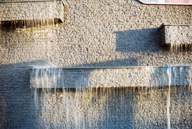 Water Splashing Down A White Brick Wall