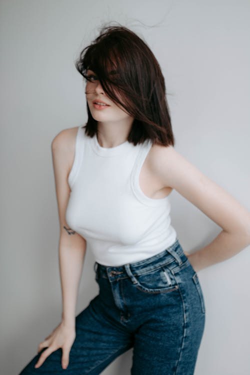 Portrait of a Pretty Brunette Wearing a White Halterneck and Jeans