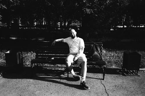 Bald Man Sitting on Wooden Bench in Park