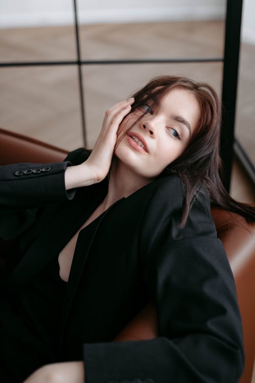 Brunette Woman in Black Jacket Posing with Hand on Face