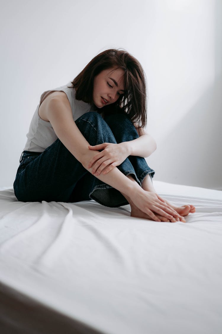 Woman On Bed Touching Her Toes