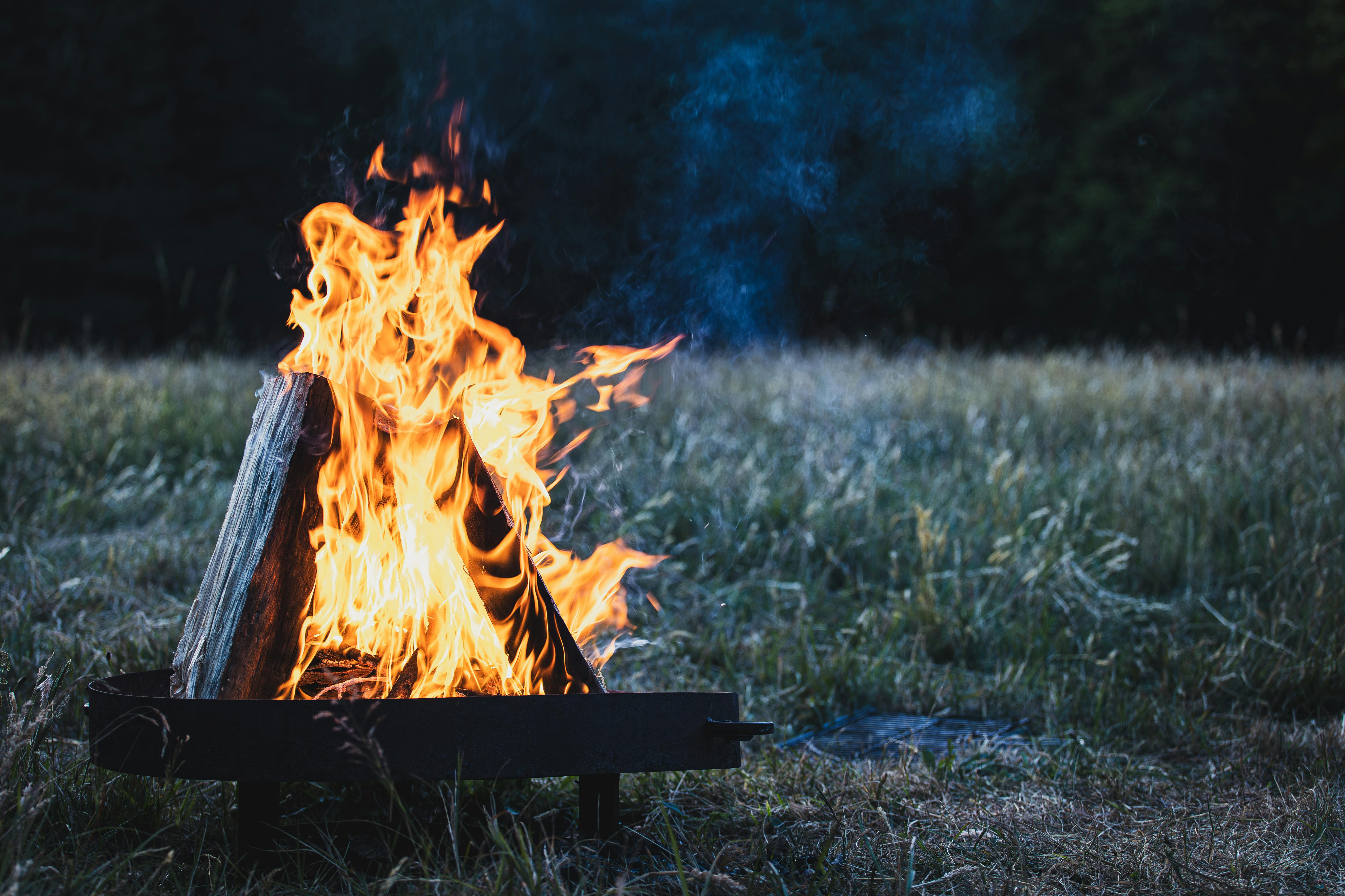 a campfire with flames in the grass