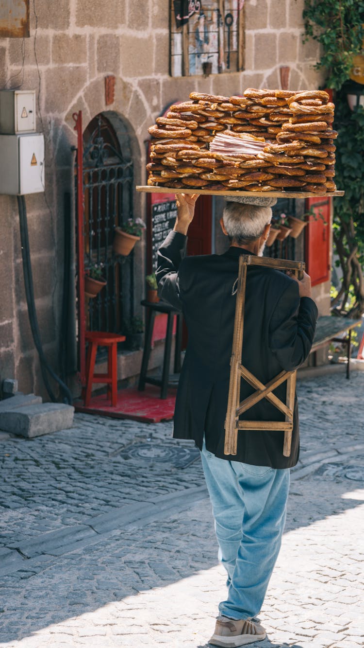 Street Vendor Carrying Freshly Baked Bread On Top Of His Head