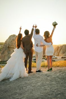 Couples celebrating a wedding at sunset in Cappadocia, Turkey, creating a joyful and romantic atmosphere.