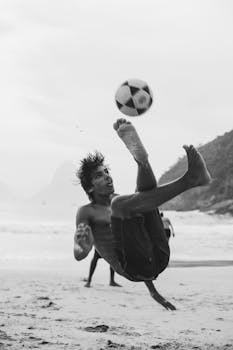 在里约海滩上，一名男子正在踢自行车，这是一张黑白照片