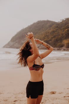 一位无忧无虑的年轻纹身女子在海滩上享受夏日时光