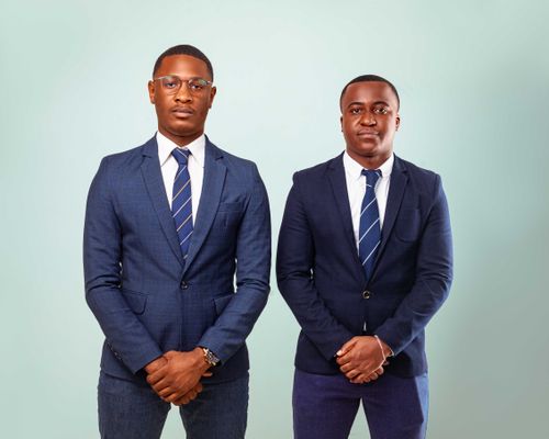 Free Two professional businessmen posing in formal suits against a neutral backdrop. Stock Photo