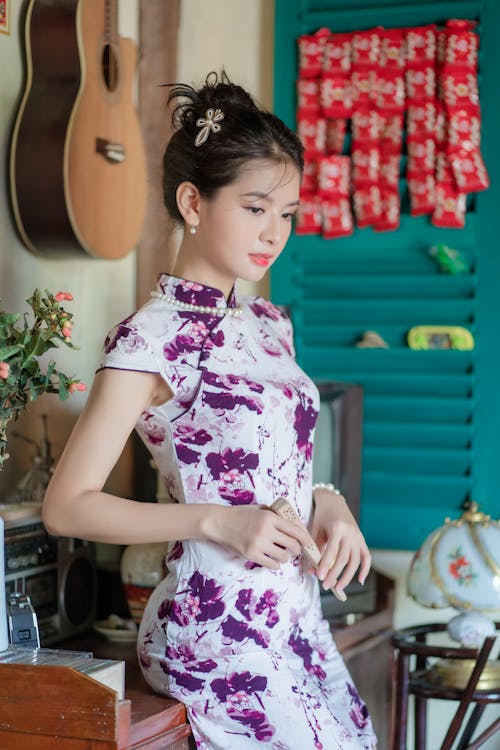 Young Woman in a Floral Dress Standing in a Room 