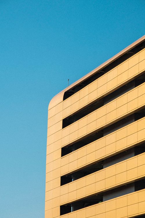 Free A modern architectural structure in Dubai showcasing sleek design under a clear blue sky. Stock Photo