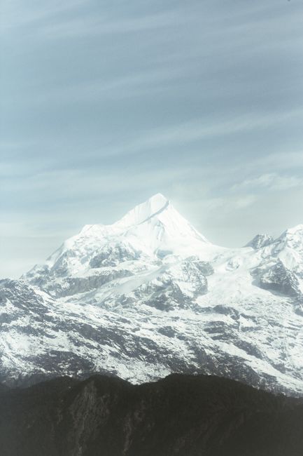 Breathtaking view of a snowy mountain peak with a clear sky backdrop, showcasing winter's beauty.