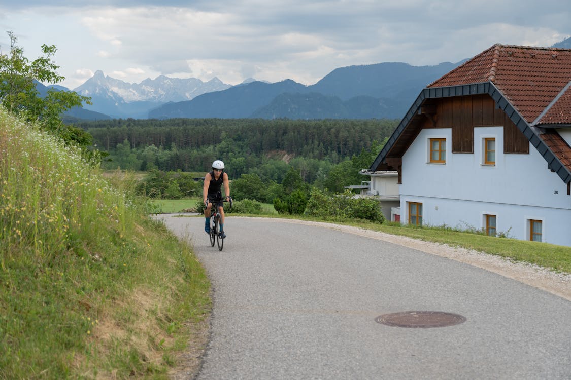 A Cyclist Riding on an Asphalt Road in Mountains 