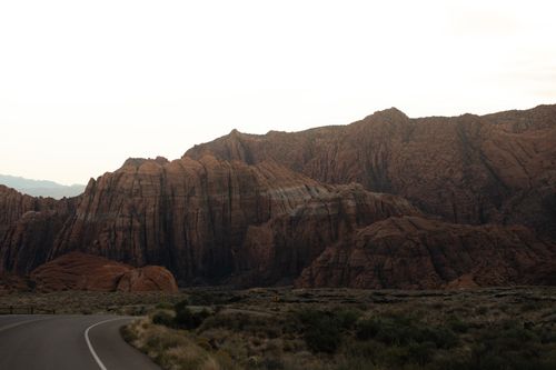 Free Captivating view of rugged desert rock formations under a moody sky at sunset. Stock Photo