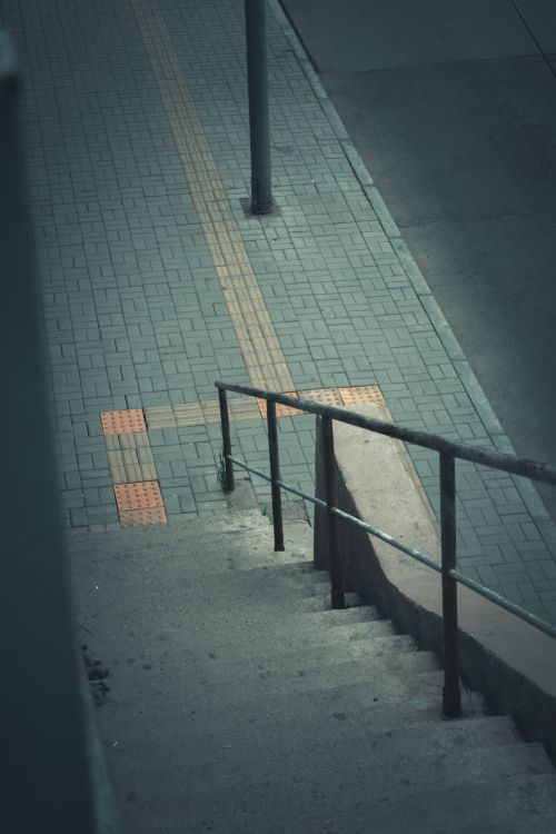 Free A view of urban stairs leading to a street with tactile paving. Ideal for city-themed projects. Stock Photo