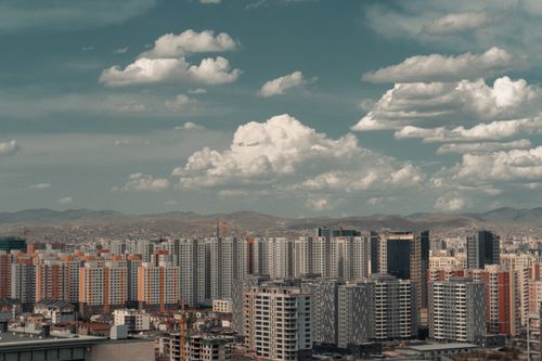 Free A scenic view of a cityscape with modern skyscrapers under a cloudy sky. Stock Photo