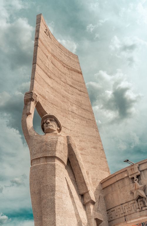 Free Impressive stone monument sculpture with cloudy sky backdrop, symbolizing historical significance. Stock Photo