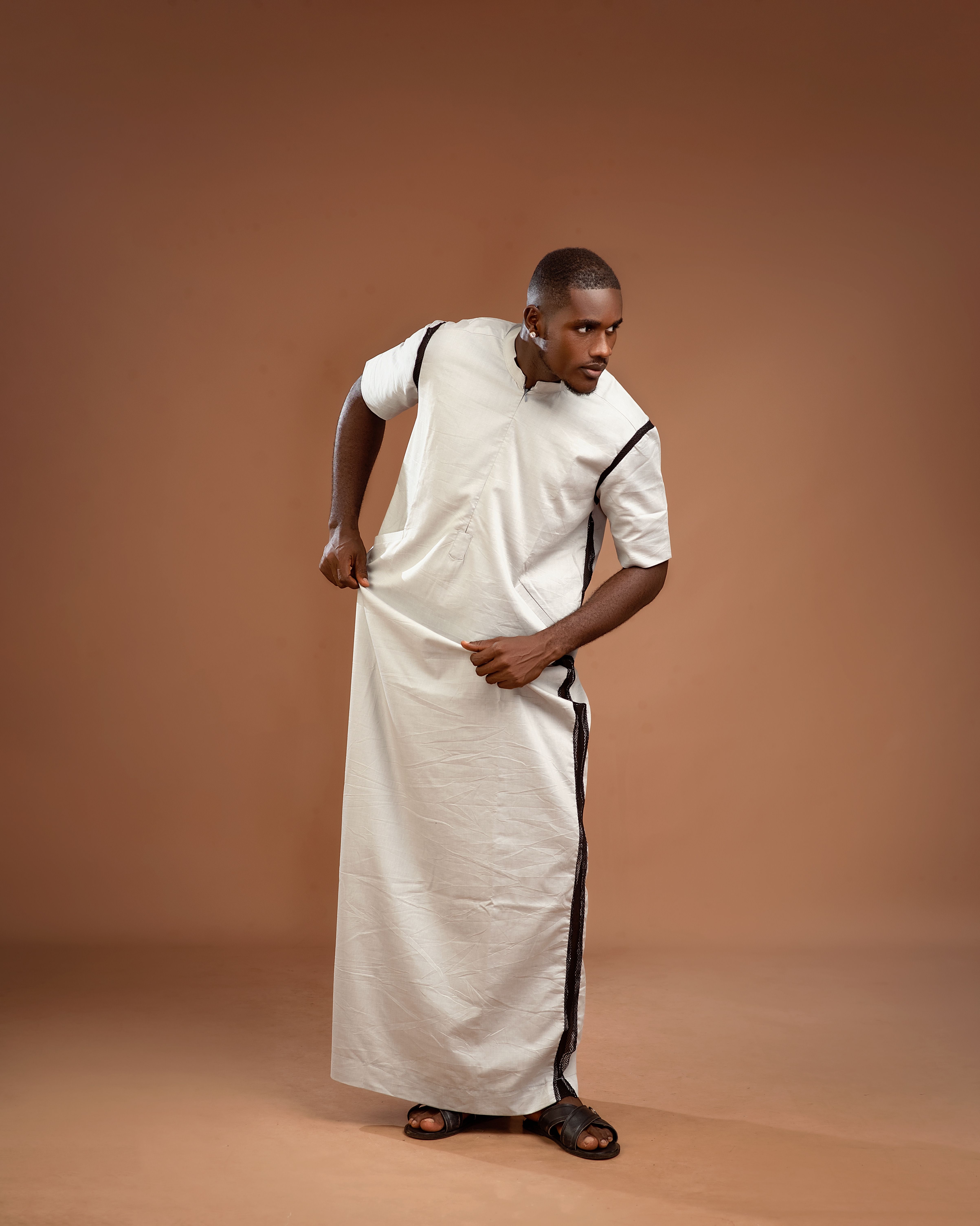 Stylish portrait of a man wearing traditional jalabiya in a studio setting.