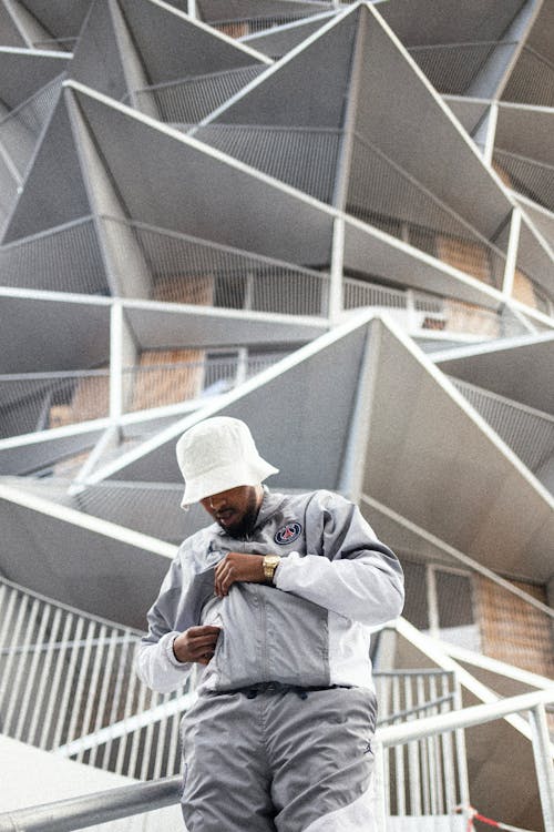 Man in Hat Standing near Futuristic Building