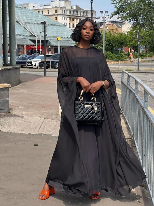 Free Stylish woman in a black dress poses confidently on a Glasgow street. Stock Photo