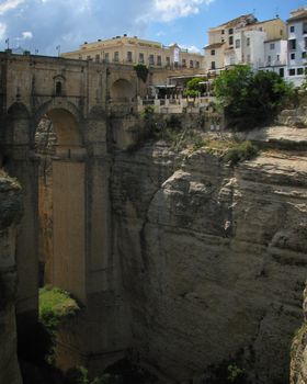 Explore the stunning Puente Nuevo Bridge in Ronda, Spain, spanning a dramatic gorge under a bright summer sky.