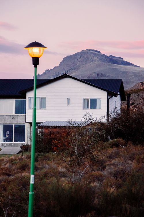 Free Charming house in San Carlos de Bariloche with mountain backdrop at twilight, featuring rustic surroundings. Stock Photo