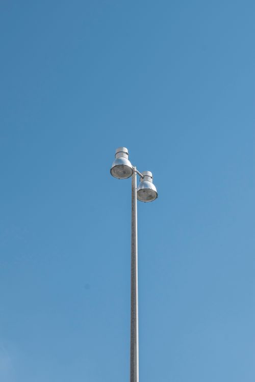 Free A tall street lamp set against a vast, clear blue sky in Dubai, UAE. Captured in a minimalist style. Stock Photo