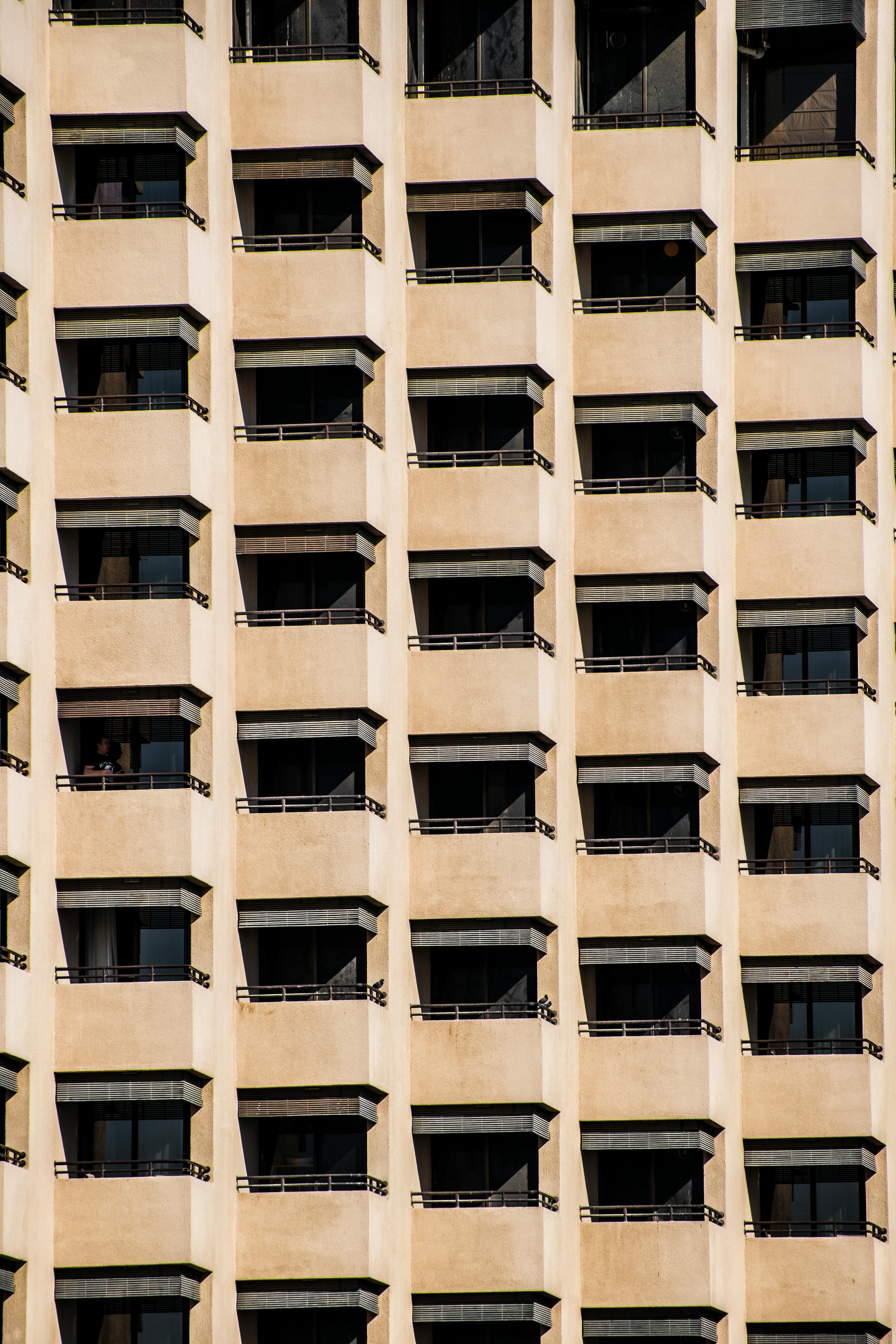 Close-up view of a sunlit building's repetitive balconies creating geometric patterns.