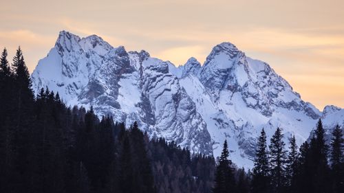 Free Explore the serene beauty of snow-capped peaks and evergreen forests at sunset in the Dolomites. Stock Photo