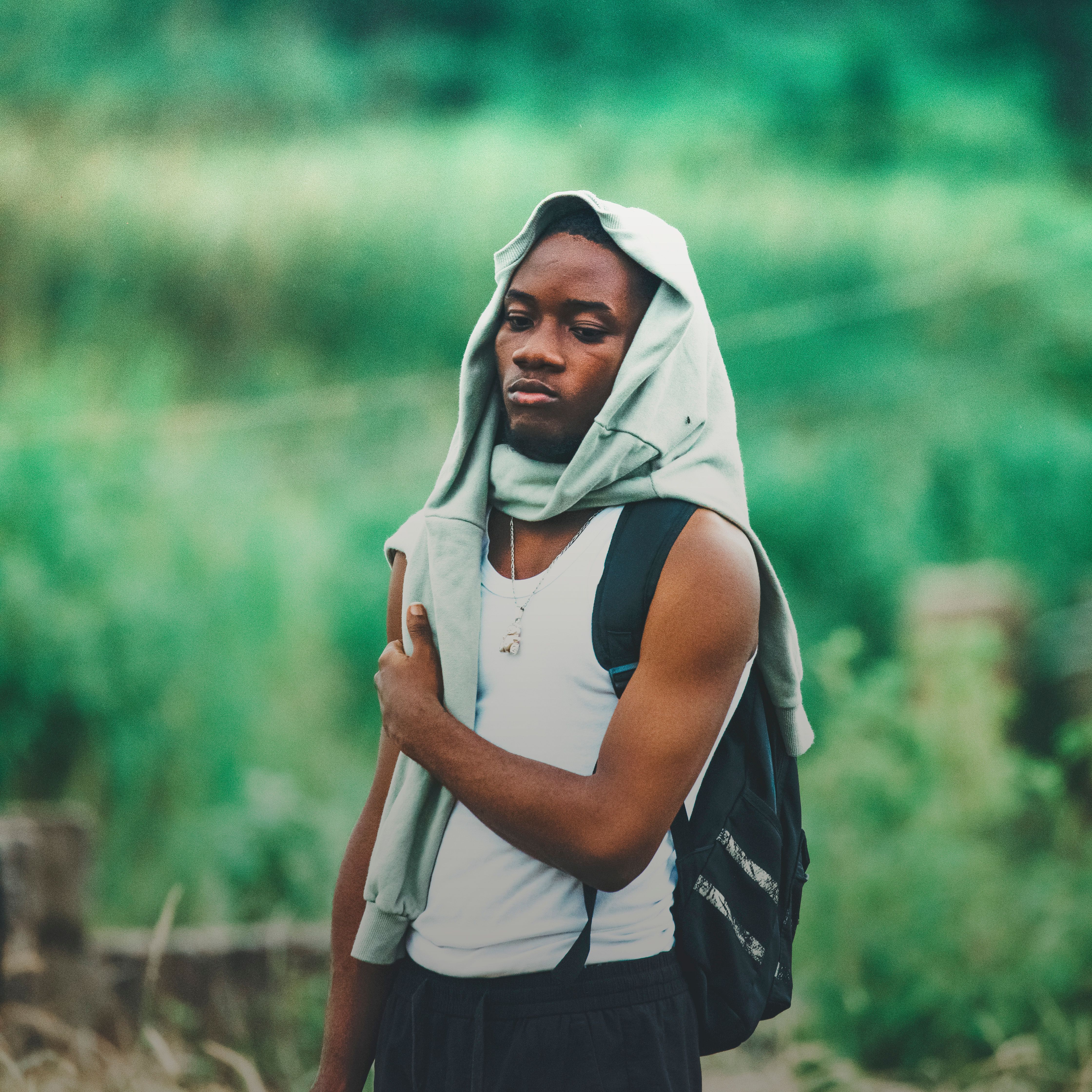 Runner in a hooded top standing in dense green scrub, photo by King Cyrus Studios on Pexels