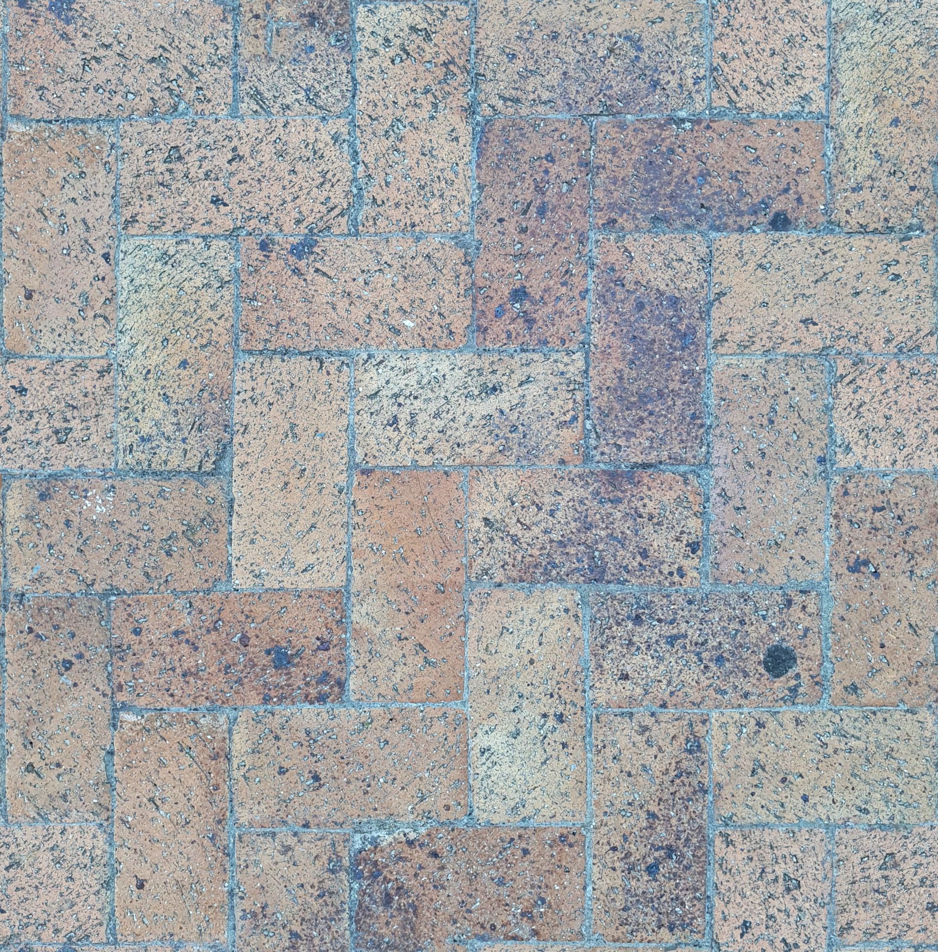 Close-up of weathered herringbone brick pavers and joints
