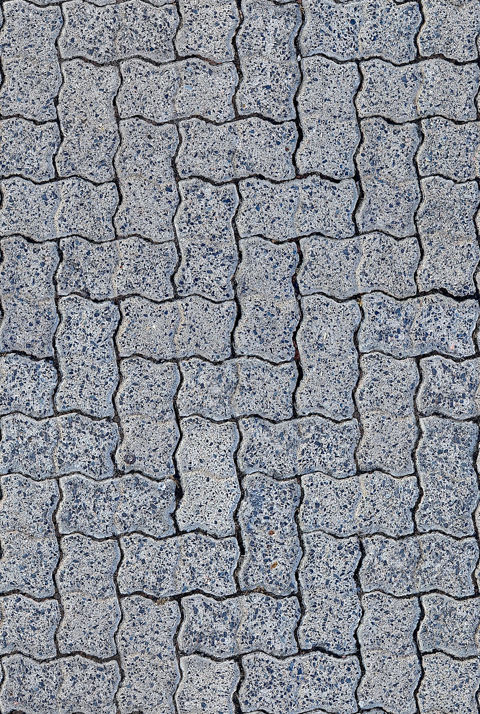 Overhead view of interlocking grey paving showing the width of the joints between each paver