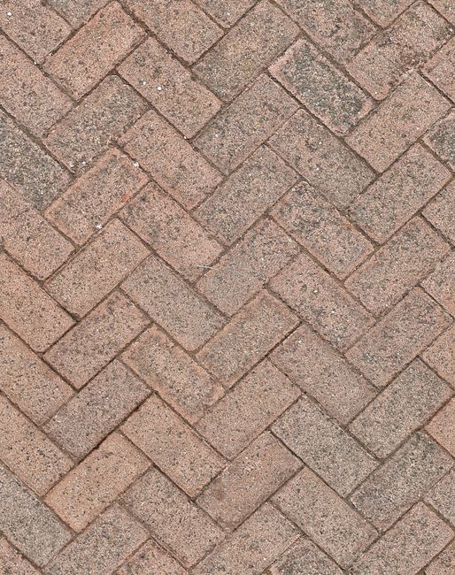 Close-up of herringbone patterned brick pavement, ideal for background texture.