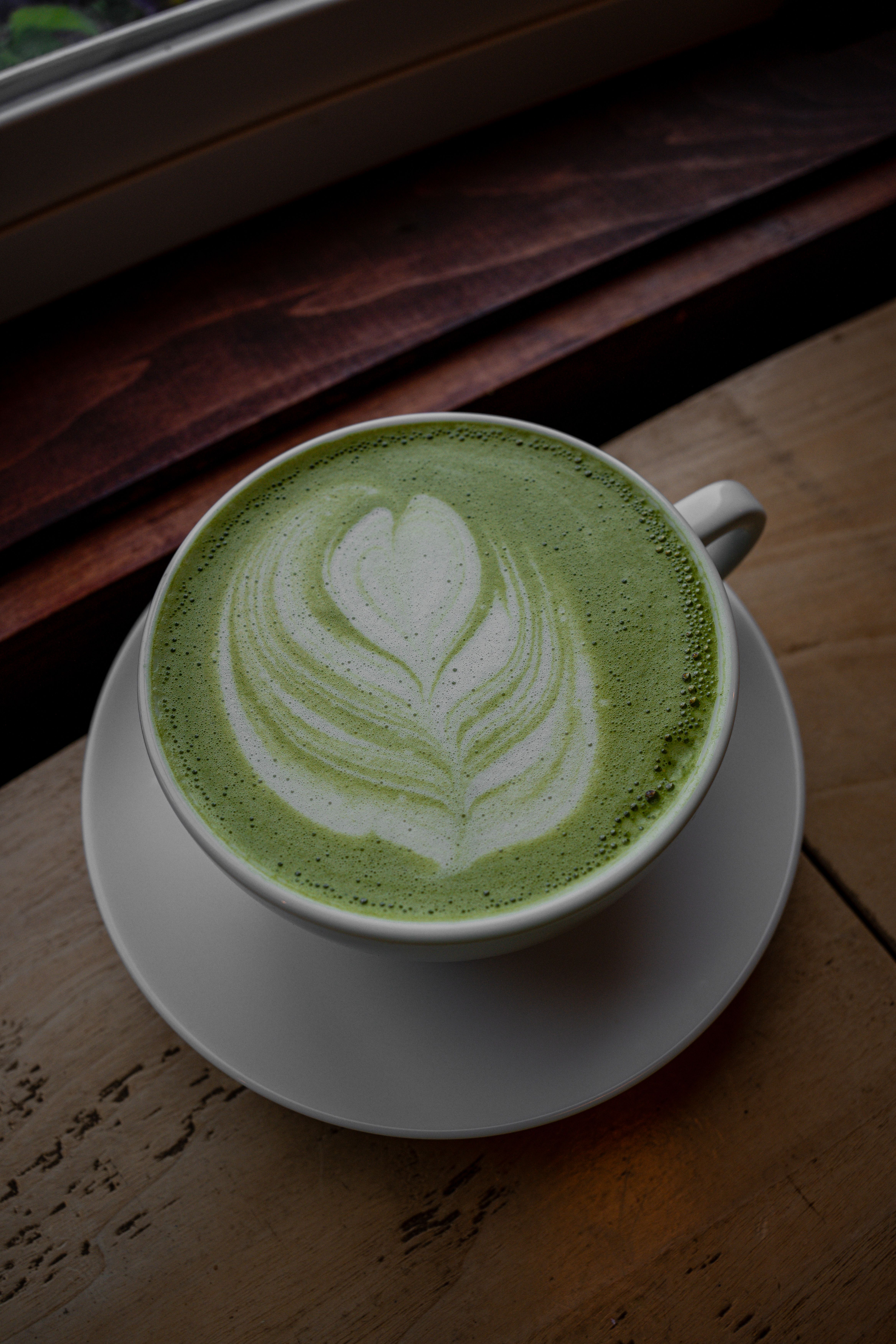 Matcha latte with latte art on a wooden table