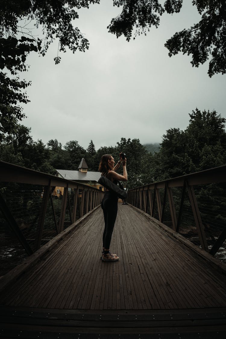 Woman Taking Photos On A Bridge