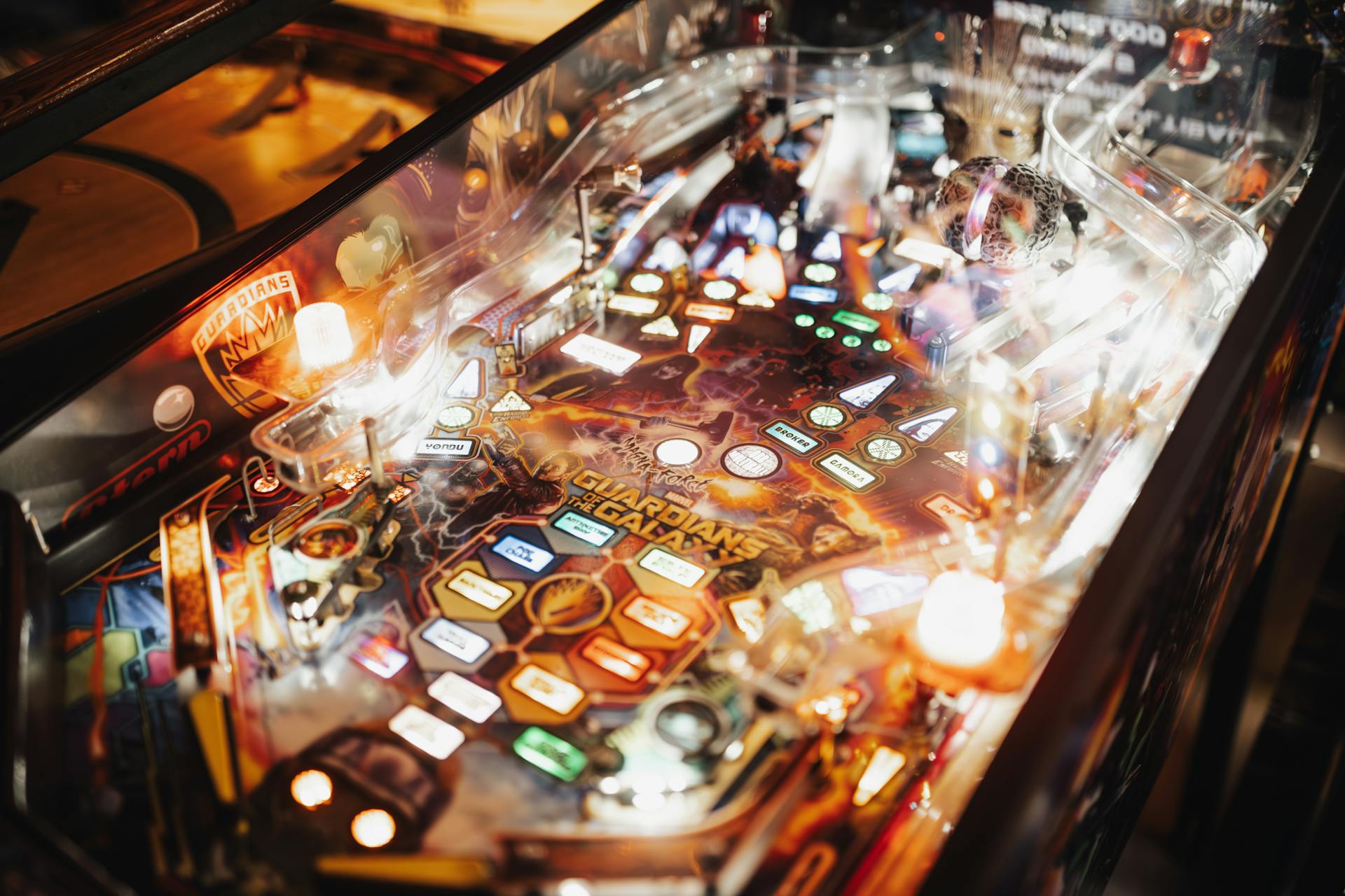 Colorful pinball machine in an arcade setting with bright lights and intricate design.