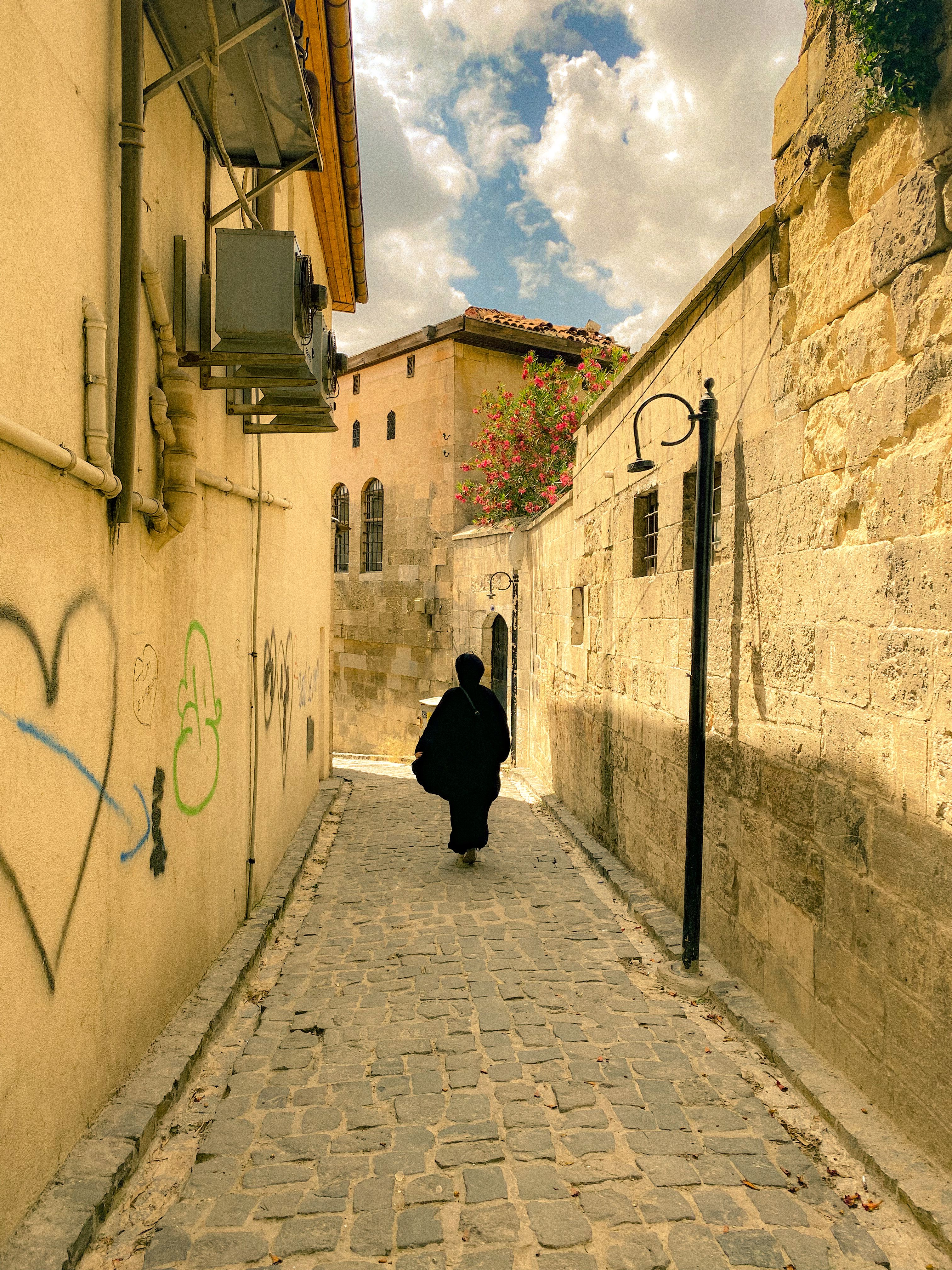 Woman Walking in a Narrow Street · Free Stock Photo