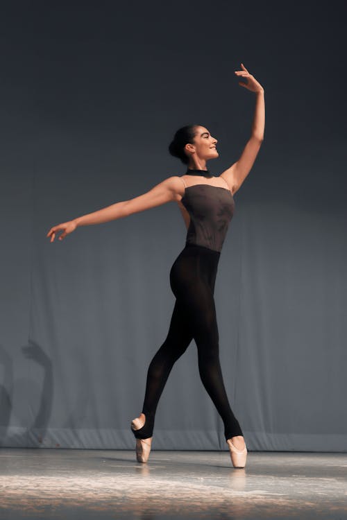 Free Smiling Ballerina Dancing with Arm Raised Stock Photo