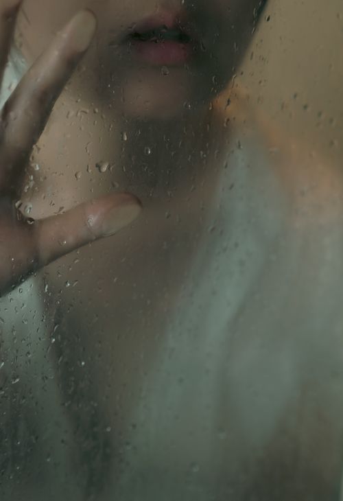 Free A mysterious close-up of a person behind foggy glass with water droplets, creating an ethereal mood. Stock Photo