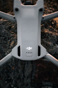 A high-angle view of a sleek drone resting on rugged terrain, showcasing technology.