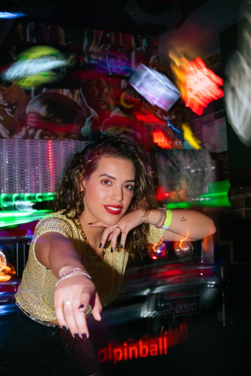 Free A joyful woman enjoying a vibrant nightlife scene with dynamic neon lights. Stock Photo