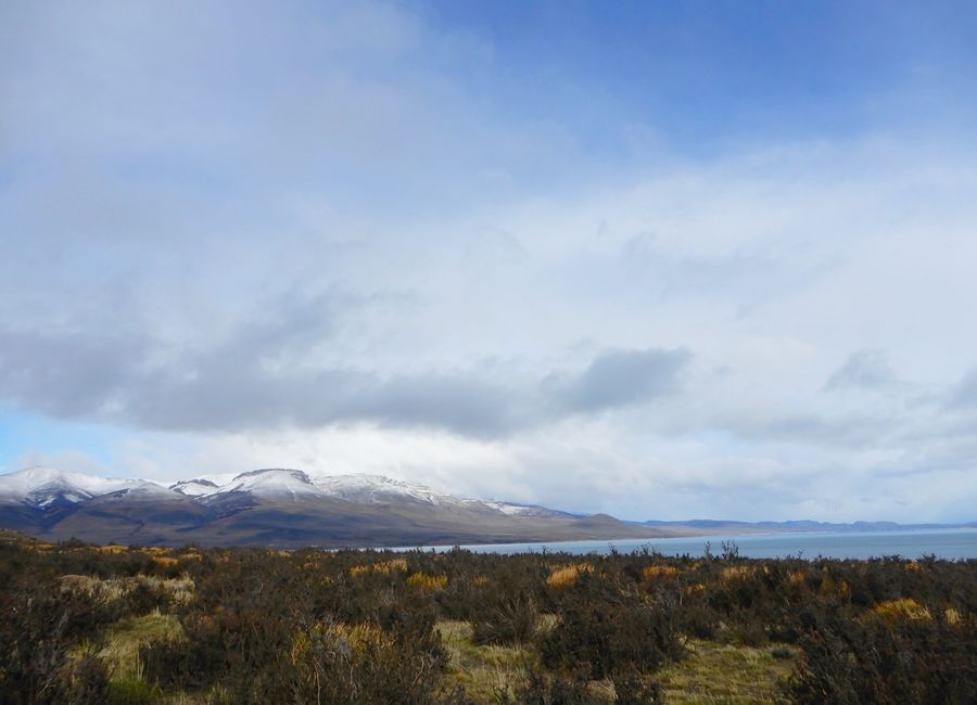 Serene landscape of snow-capped mountains and expansive lake in Torres del Paine, Chile.