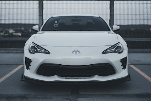A sleek white Toyota sports car parked in an urban environment, highlighting its modern design.