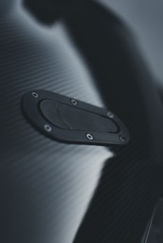 Artistic close-up of a carbon fiber vehicle surface showcasing texture and sleek design.