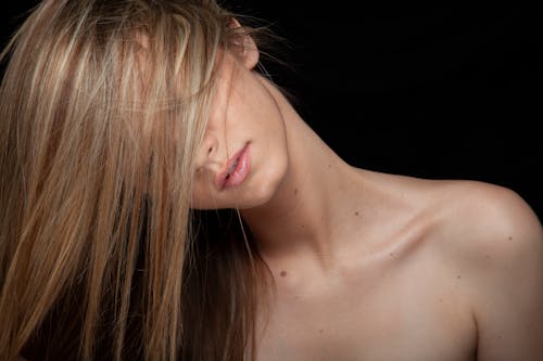 Studio Shot of a Topless Woman Covering Her Face with Hair 