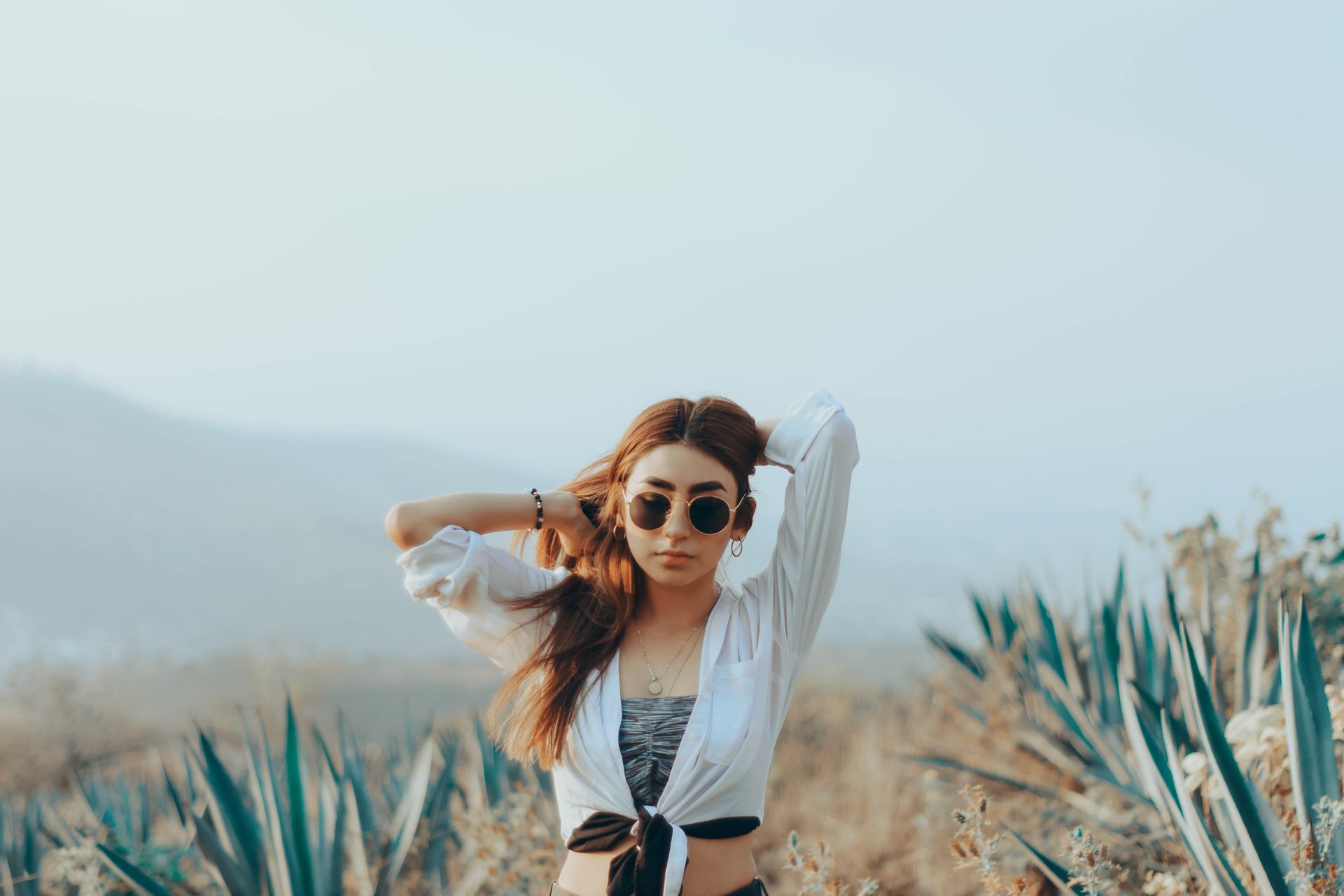 Young Woman with Hands in Her Hair among Agaves