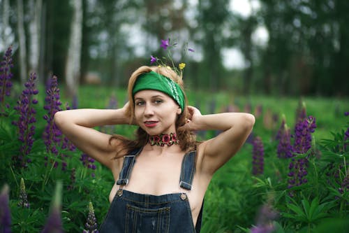 Young Woman Posing on a Field between Flowers