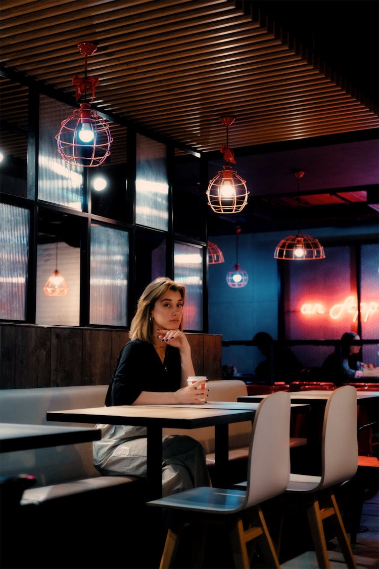 A Woman Sitting At A Cafe 